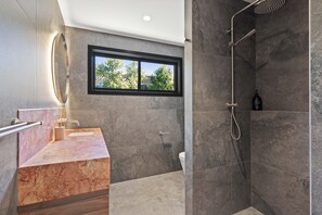 Enjoy a functional and stylish bathroom with a walk-in shower, handheld showerhead, and large mirror.