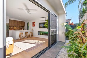 Enjoy a spacious living area with a kitchen, sliding door to an outdoor space, and seating for relaxation.