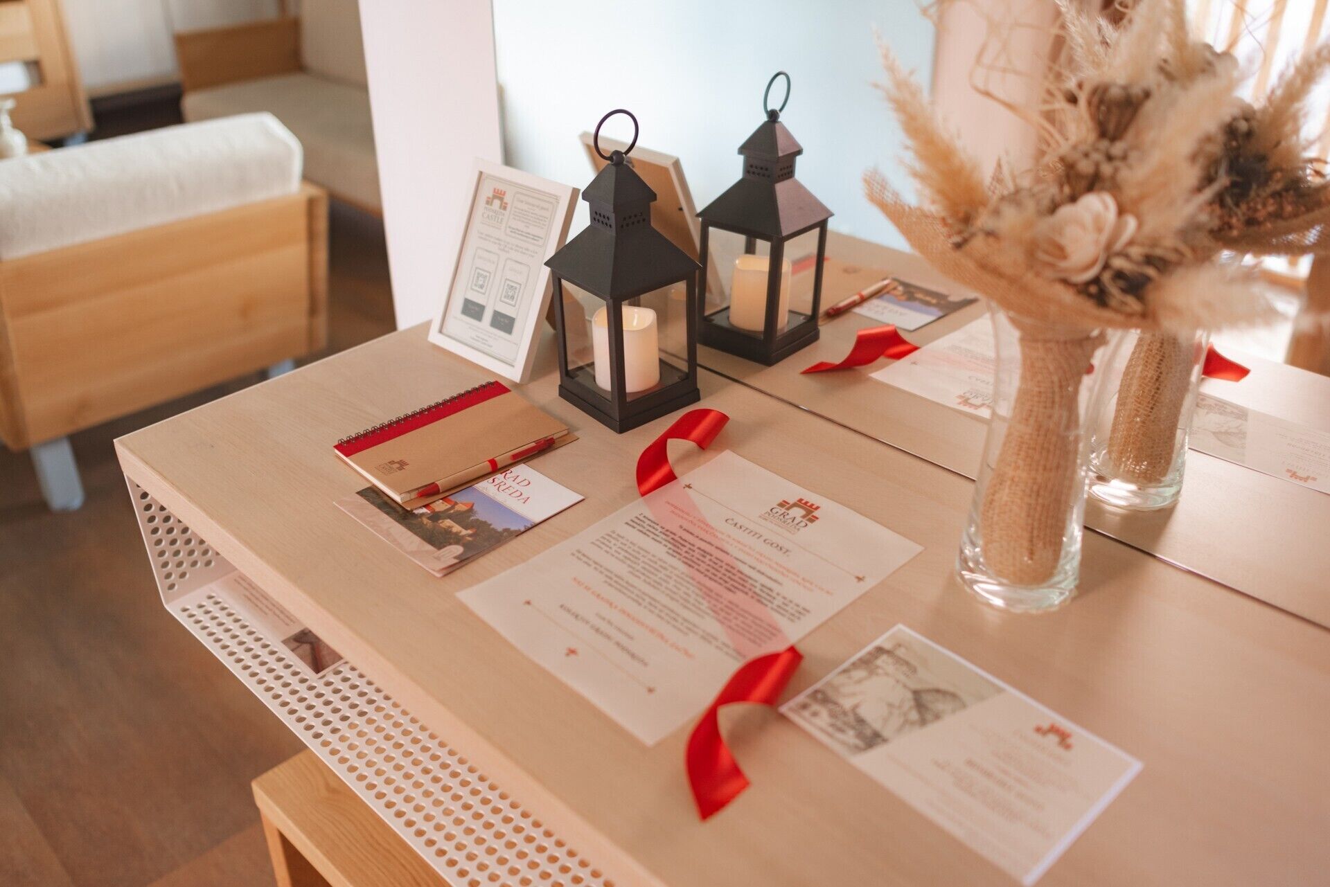 A table with documents, a red ribbon, and two black lanterns.