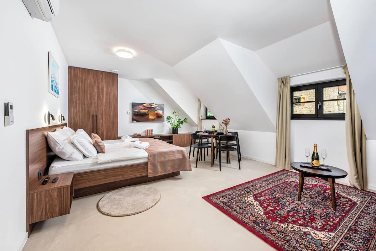 Un dormitorio moderno con cama estilo loft, un escritorio pequeño y una mesa de comedor.