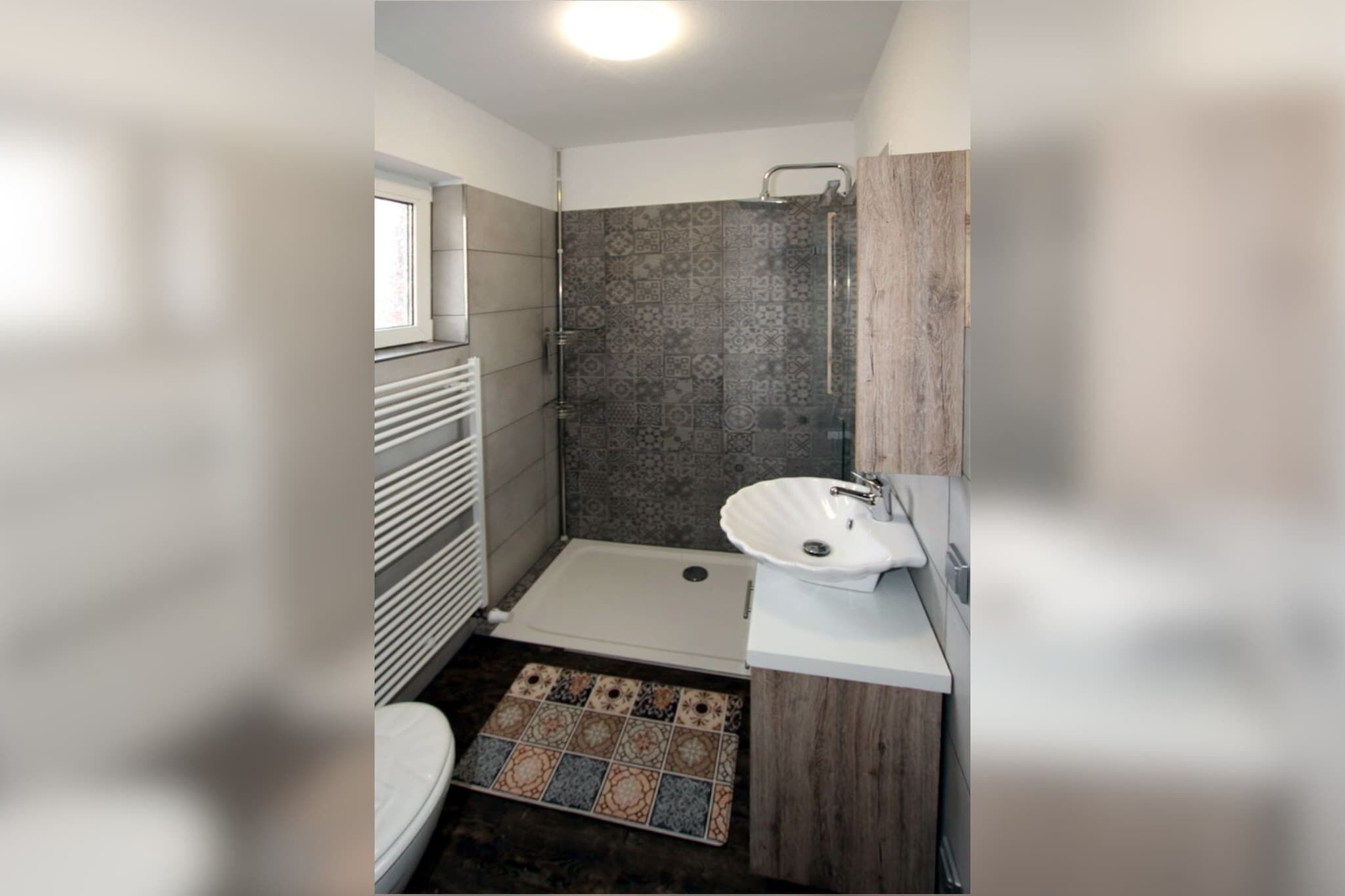 Un baño pequeño con ducha, inodoro y lavamanos.