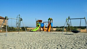 A playground with swings and slides on a sandy surface. - Apartment in Campiglia Marittima (Campiglia Marittima)