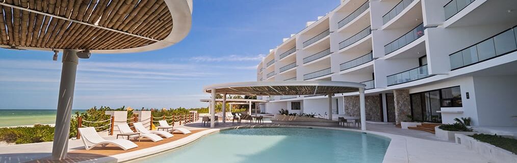 Et resort med pool, liggestole og havudsigt.