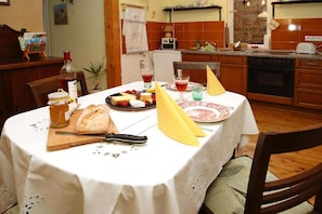 Enjoy a meal at the dining table, set with a variety of food and drinks.