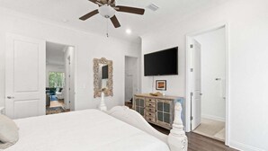 A bedroom with a large bed, a ceiling fan, a TV, and a dresser. - Fall Deals + Snowbird Rates | Lake View, Pool, Close to the Beach (Santa Rosa Beach)