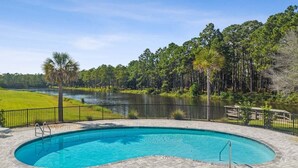 A swimming pool with a view of a lake and trees. - Fall Deals + Snowbird Rates | Lake View, Pool, Close to the Beach (Santa Rosa Beach)