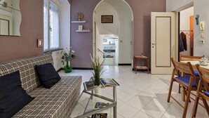 Una sala de estar con un sofá, una mesa de centro y una zona de comedor con sillas y una mesa.