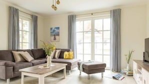 Ein modernes Wohnzimmer mit Ecksofa, Couchtisch und TV-Schrank.