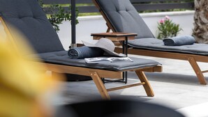 Dos sillones con cojines, una mesita pequeña y una toalla enrollada.