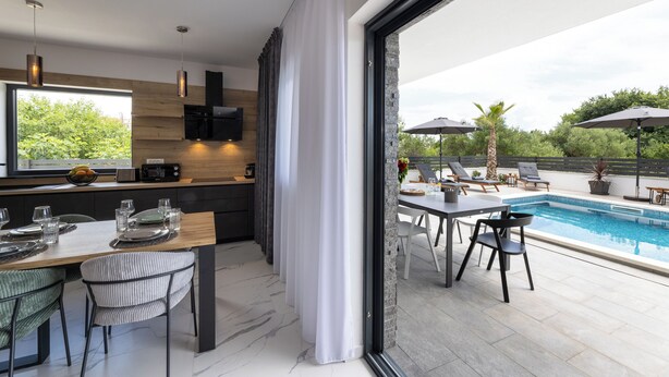 Cocina moderna con comedor y ambiente junto a la piscina.