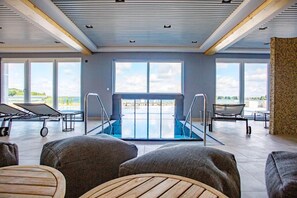 Relax by the pool with a view of the water body, surrounded by lounge chairs and a small table.
