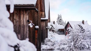 A wooden building with a snow-covered roof and a visible chimney. - Ferienhäuser, Torfhaus (Torfhaus)
