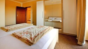 Une chambre d’hôtel avec un lit, une armoire et un miroir.