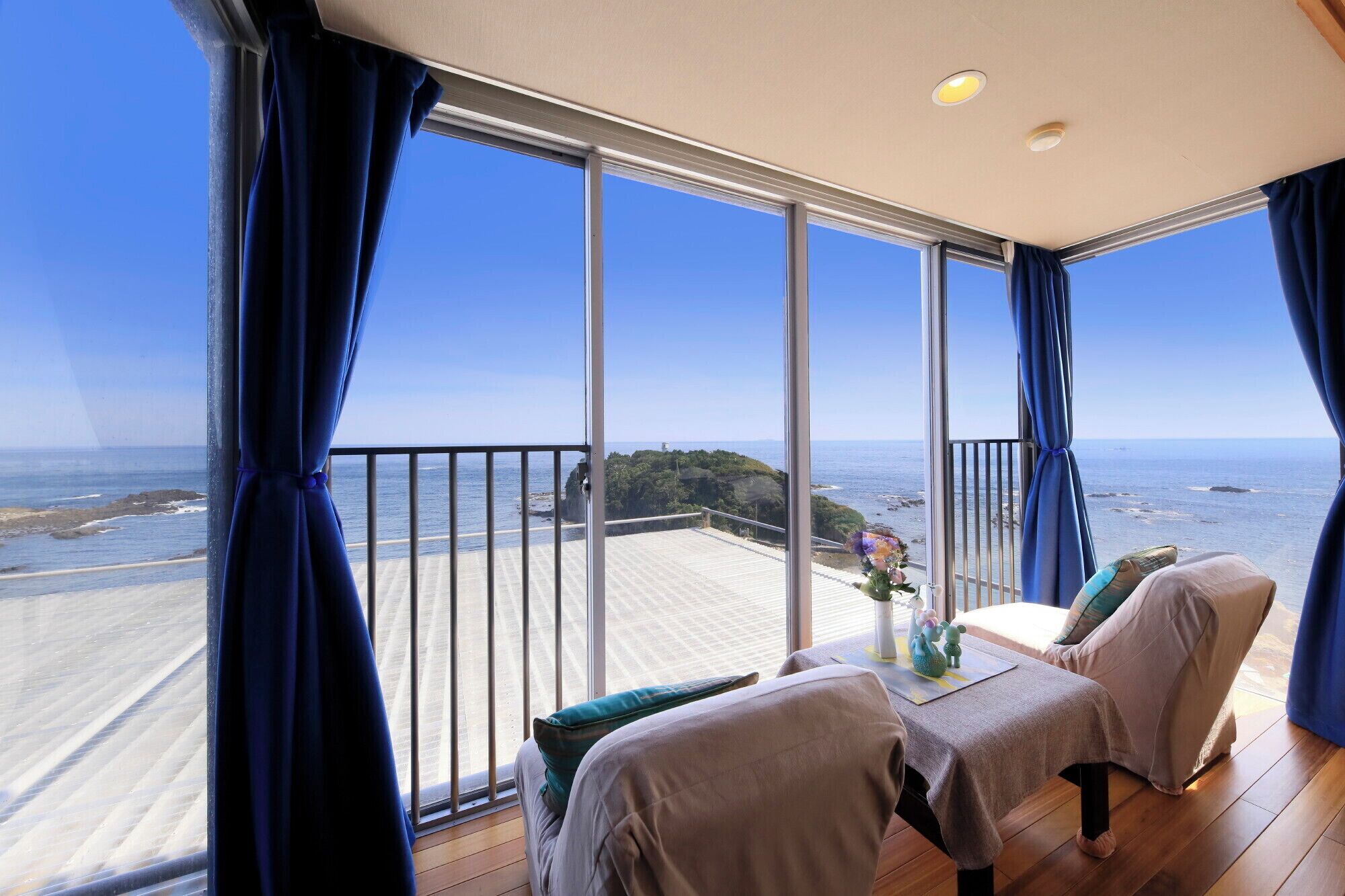 A balcony with a view of the sea and rocky coastline.