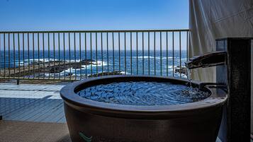 Ein Whirlpool auf einem Balkon mit Blick auf das Meer.