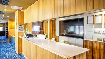A reception area with a wooden panel wall, a reception desk, and a large window.