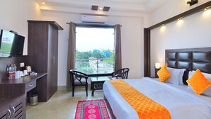 Une chambre d’hôtel avec un lit, une télévision, un bureau et un balcon.