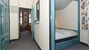 Un dormitorio con literas, un armario y un espejo.