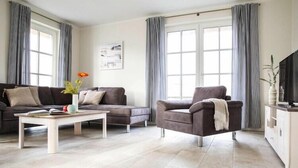 Una sala de estar moderna con un sofá, un sillón y una mesa de centro.