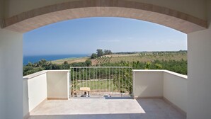 Un balcon avec vue sur la mer et les champs.