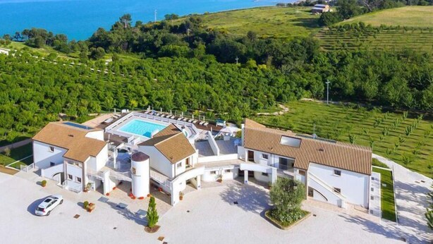 Un complexe hôtelier doté d’une piscine, de plusieurs villas et offrant une vue sur la mer.