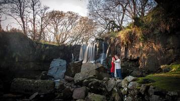 Una cascada rodeada de rocas y árboles.