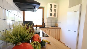A kitchen with white cabinets, a white refrigerator, a window, and a sink. - holiday home directly at the lake, Dabie (Dabie)
