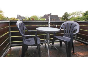 Sit and enjoy the view from this outdoor seating area with a round table and two chairs.