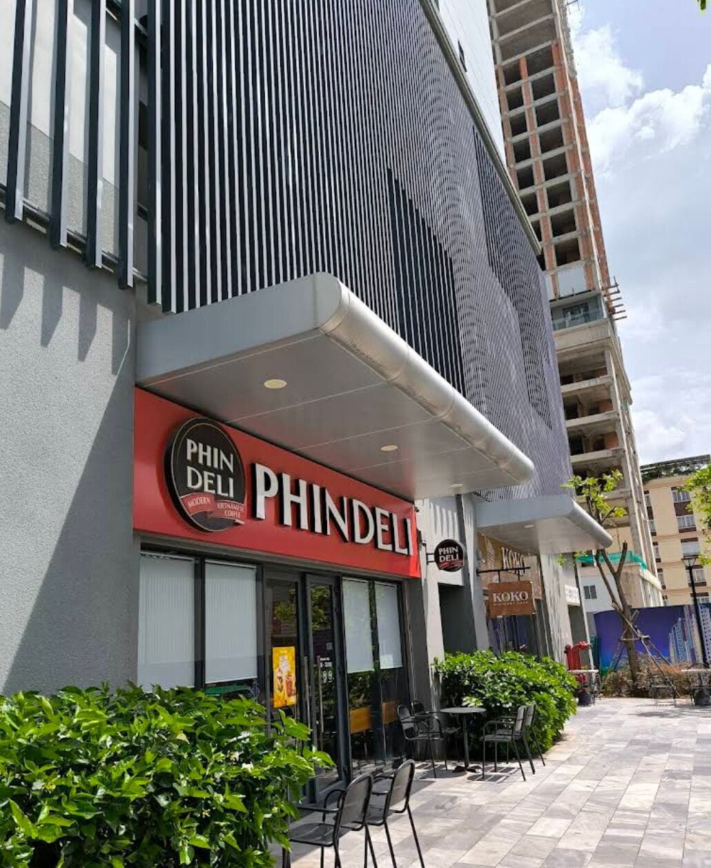 A PHINDELI restaurant with outdoor seating and a modern building facade.