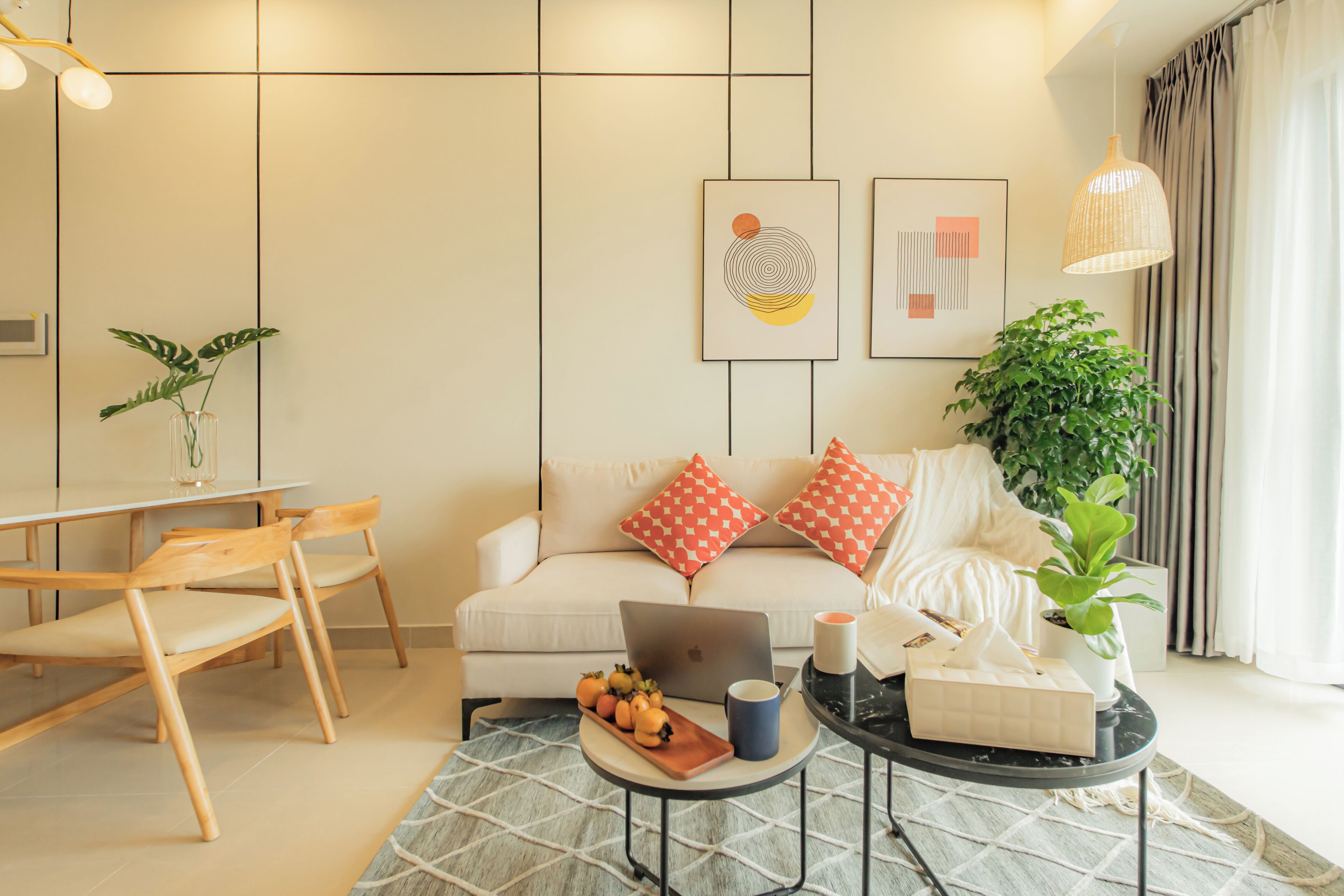 A modern living room with a sofa, coffee table, and dining area.