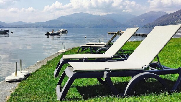 Une vue sur le lac, avec des chaises longues et des bateaux.
