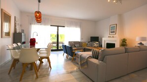 Ein modernes Wohnzimmer mit einem Glastisch, Sofas und einem Kamin.