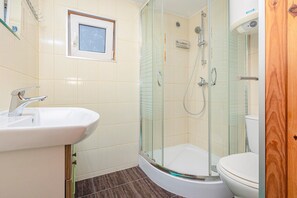 Een badkamer met een douchecabine, een wastafel en een toilet.
