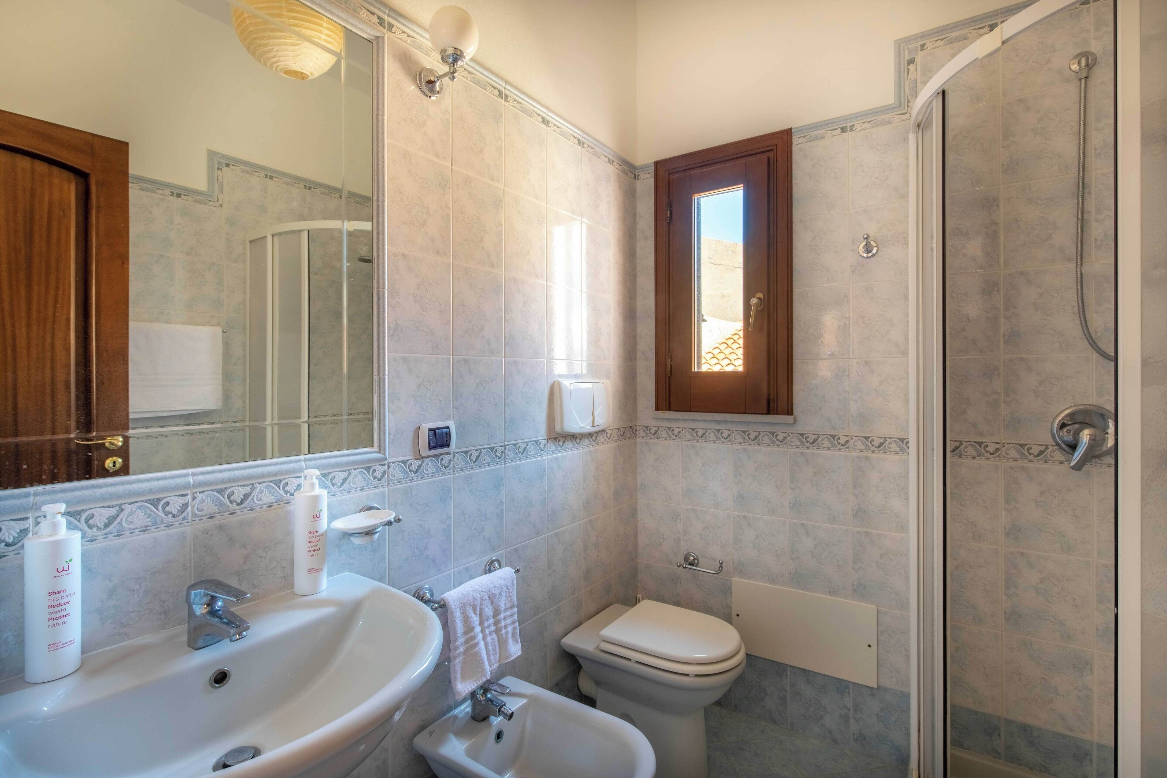 Un bagno con lavandino, WC e doccia.