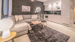 Moderni olohuone, jossa on sohva, sohvapöytä ja matto.