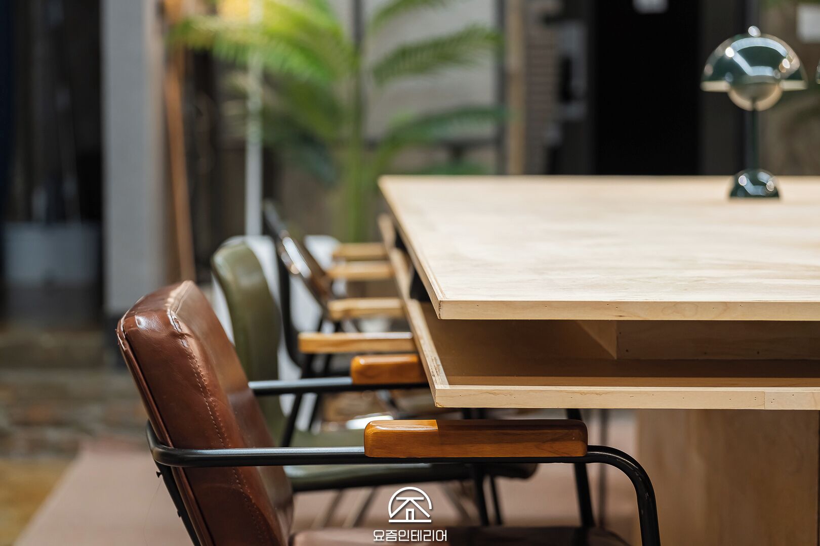 A conference room with a wooden table and leather chairs.