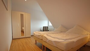 Ein Schlafzimmer mit Bett, Kleiderschrank und Heizkörper.