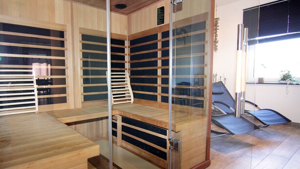 Una habitación con separador de vidrio, estantes de madera y una ventana.