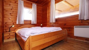 A wooden cabin bedroom with a single bed, two bedside tables, and a ceiling fan. - Blockhaus, Hasselfelde (Hasselfelde)