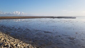 A wide, open water body with a rocky shoreline. - Exklusiv eingerichtetes Ferienhaus in Strandnähe (Dagebüll)