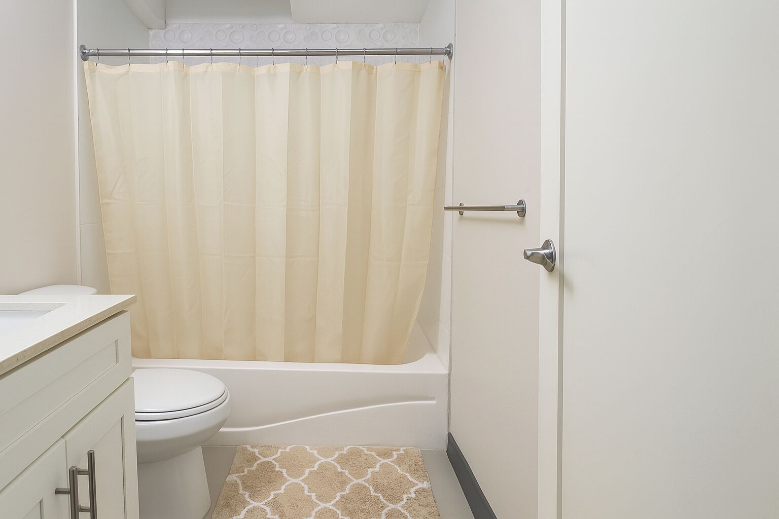 A small, clean bathroom with a toilet, a bathtub, and a shower curtain.