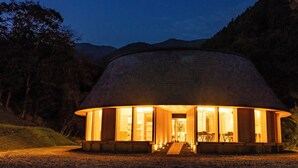 A circular wooden structure with large windows, a staircase leading up, and a bench outside. - Nordisk Hygge Circles UGAKEI (Inabe)
