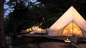 A row of dome-shaped tents with a wooden deck and a table with a lantern. - Nordisk Hygge Circles UGAKEI (Inabe)