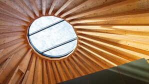 A circular skylight with a wooden ceiling structure radiating outward. - Nordisk Hygge Circles UGAKEI (Inabe)