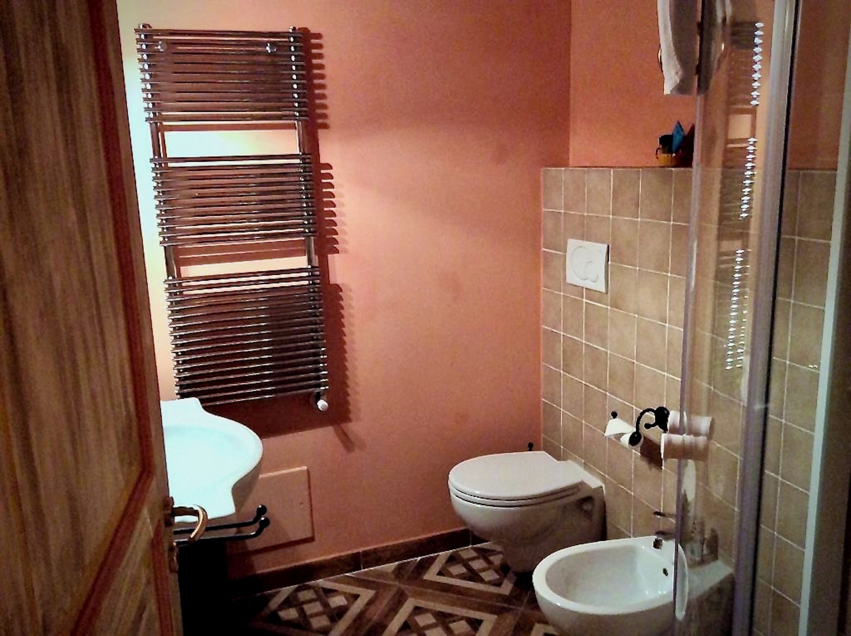Une petite salle de bain comprenant des toilettes, un bidet et un porte-serviettes.