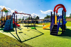 Un parque infantil con diversas estructuras de juego, como columpios, toboganes y zonas de escalada.
