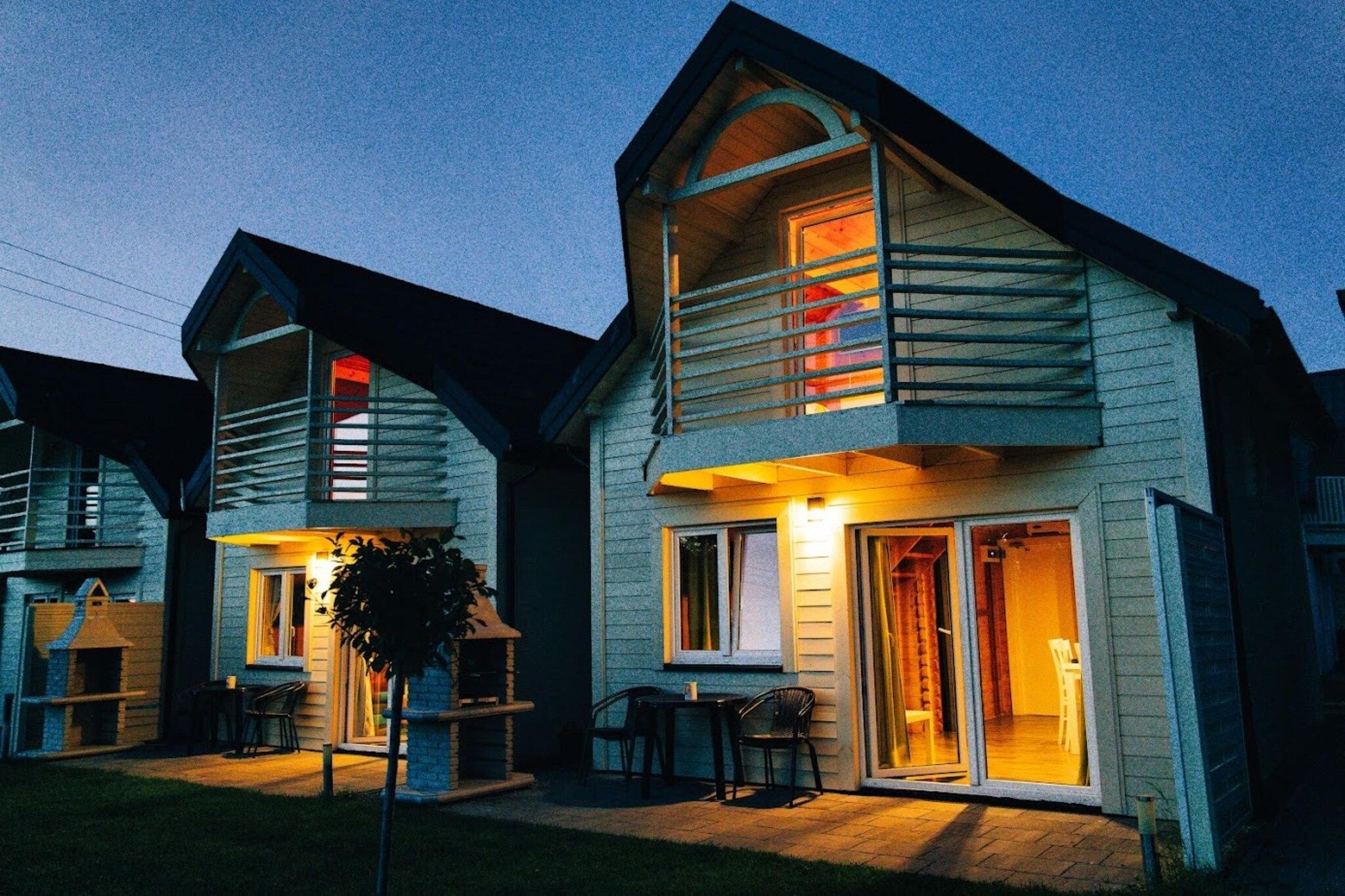 A two-story house with a balcony and a patio area.