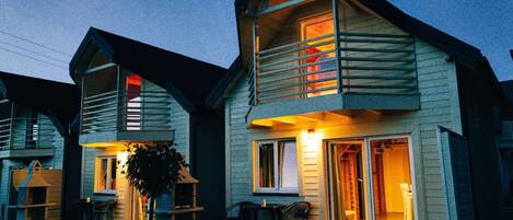 A two-story house with a balcony and a patio area.