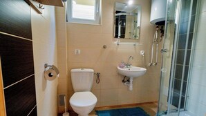 Ein Badezimmer mit Toilette, Waschbecken und Dusche.
