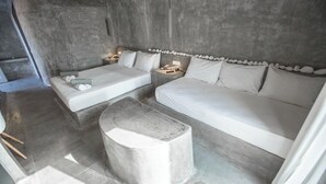 Une chambre à coucher moderne avec un grand lit, un petit canapé et une table de chevet.